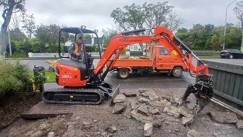 Digger breaking out old paving before a new concrete pour