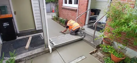 Concreter forming a new concrete entrance path in Palmerston North