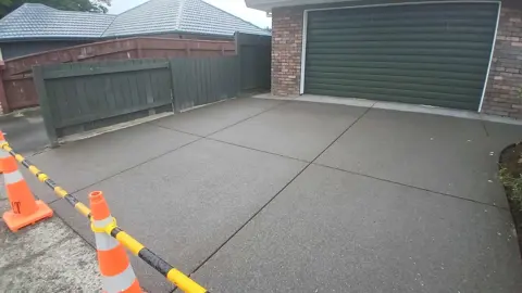 Exposed aggregate concrete driveway apron in front of a garage in Palmerston North