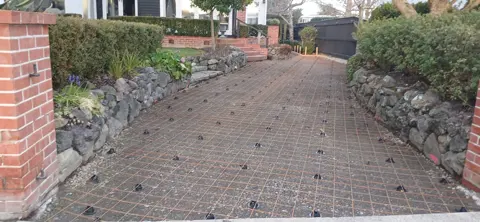Reinforcing mesh set out between brick gate pillars before a driveway pour in Palmerston North