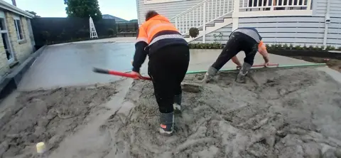Crew screeding a fresh concrete driveway pour in Palmerston North