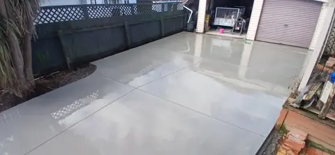 Smooth finished concrete driveway beside a lattice fence in Palmerston North