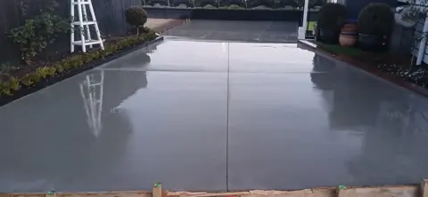 Freshly finished concrete driveway with saw-cut control joints, Palmerston North